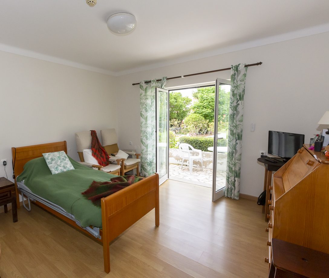 A bright bedroom with garden doors opening onto a private patio